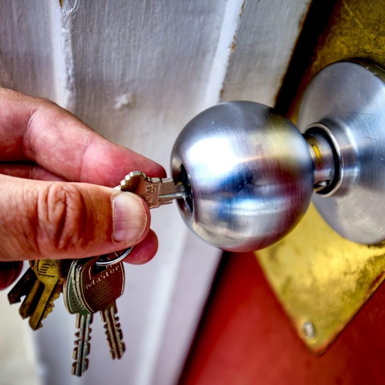 Hombre sostiene en la mano bombín con llave. Hombre sostiene en la mano bombín con llave.